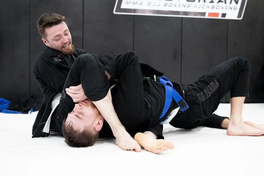 BJJ Gi member applying an armbar during technical training at Praetorian MMA