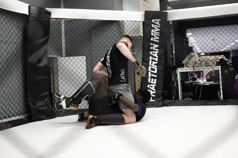 Ben Hudson Wilde in a ground and pound position during MMA training inside the cage at Praetorian MMA