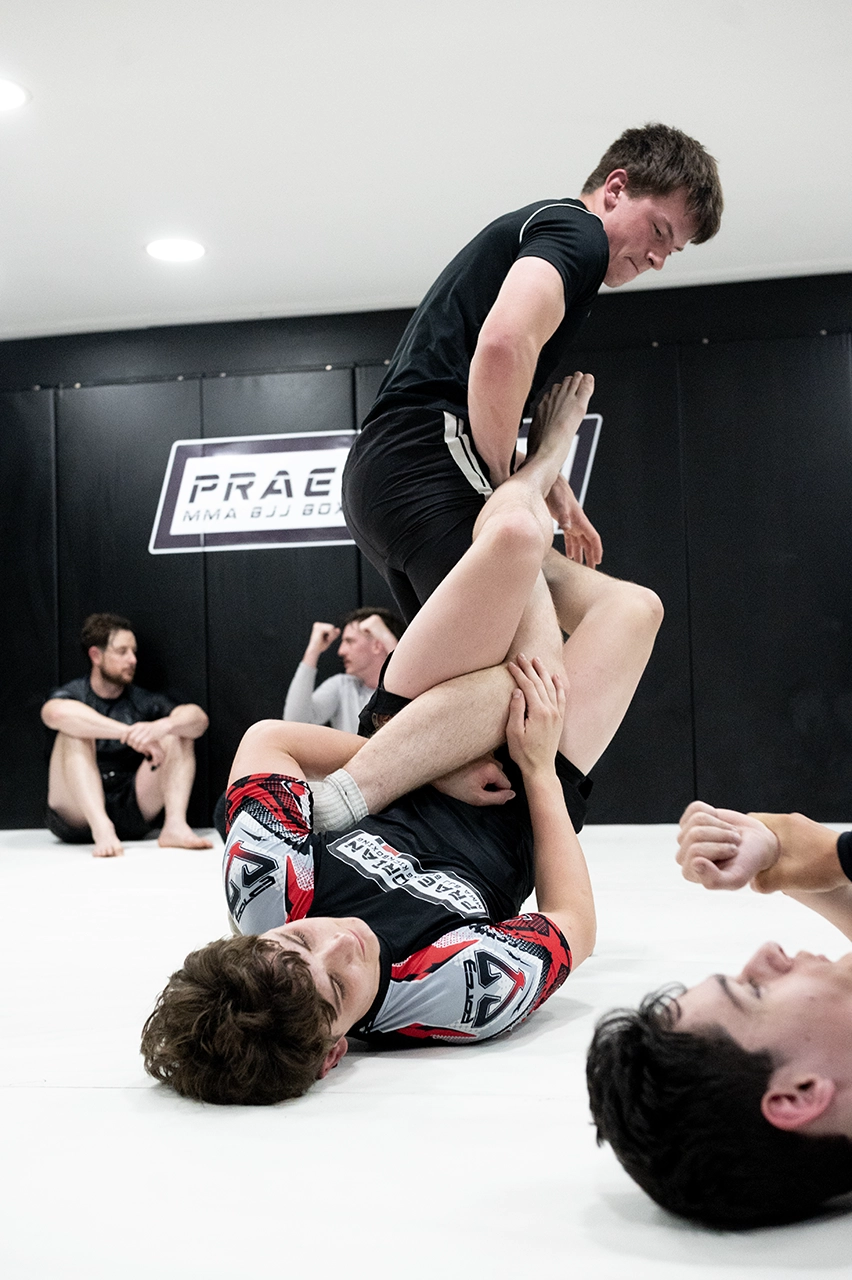 Cian Brown supporting a child or teen during class at Praetorian MMA
