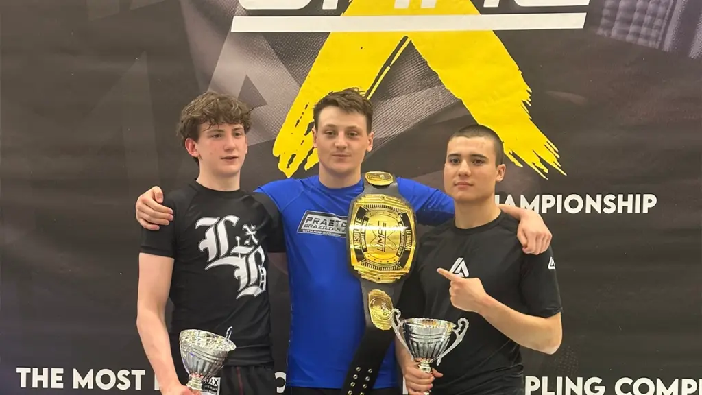 Josh Woodbourne standing on top of the podium after winning his first championship belt