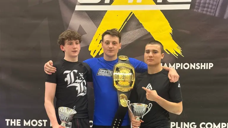 Josh Woodbourne standing on top of the podium after winning his first championship belt