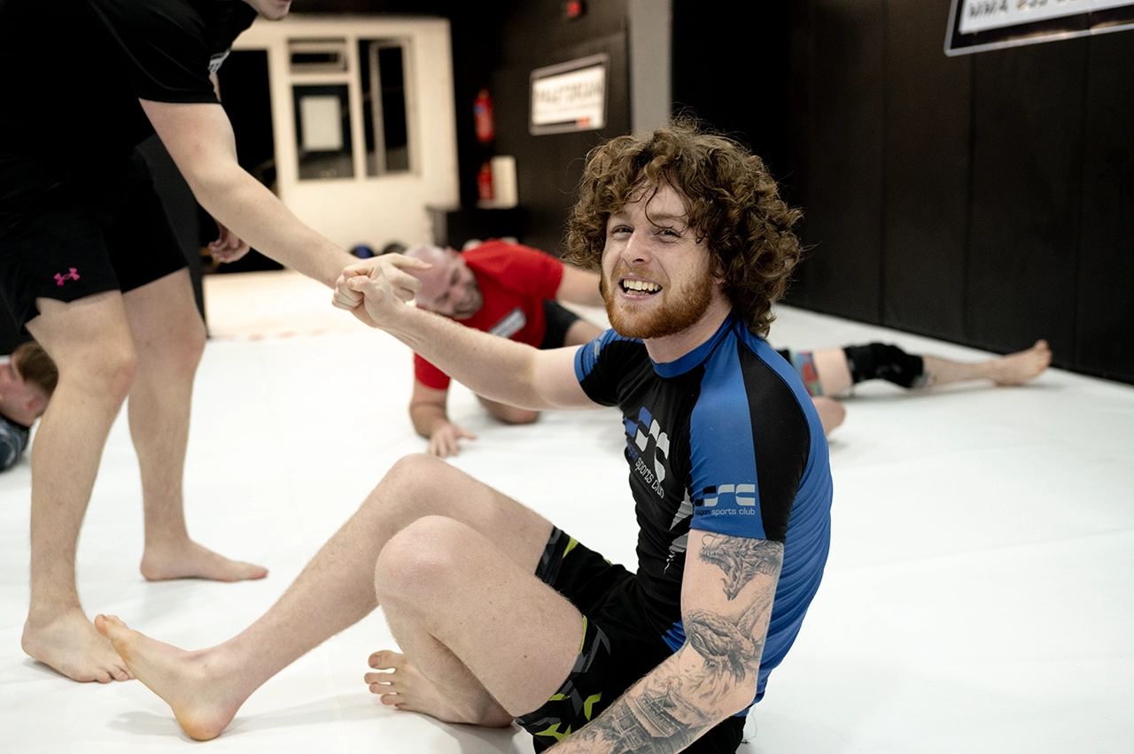 Nathan Johnstone smiling and fist bumping a Praetorian MMA member before rolling in NoGi
